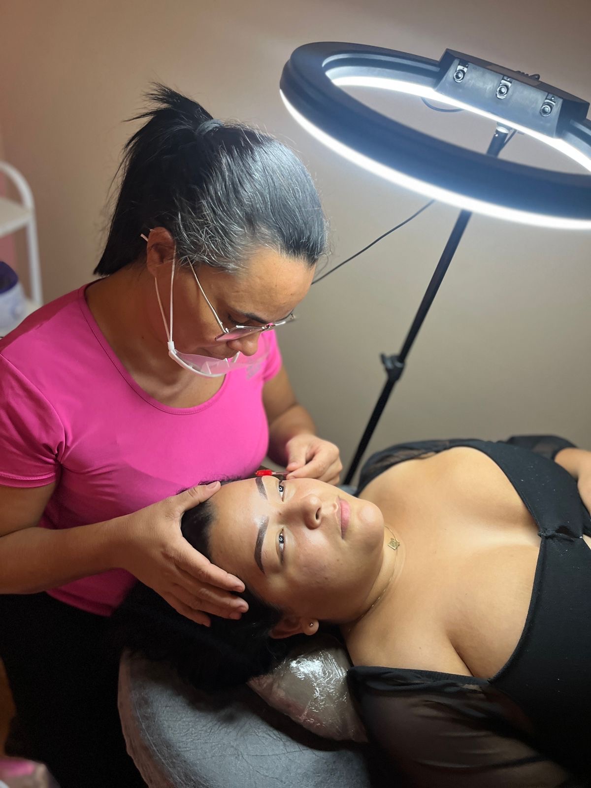 Profissional realizando design de sobrancelhas